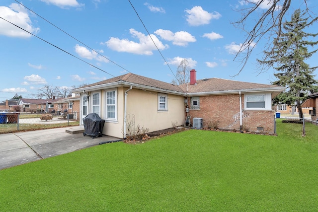 back of property with a patio area, a lawn, and central air condition unit