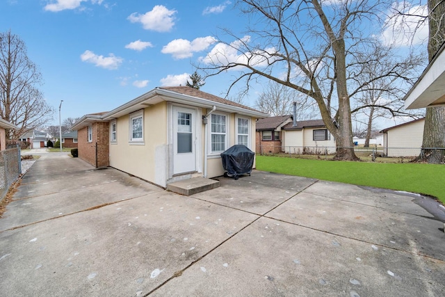 back of house with a patio and a yard