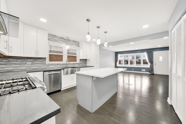 kitchen with sink, white cabinetry, hanging light fixtures, a center island, and stainless steel dishwasher