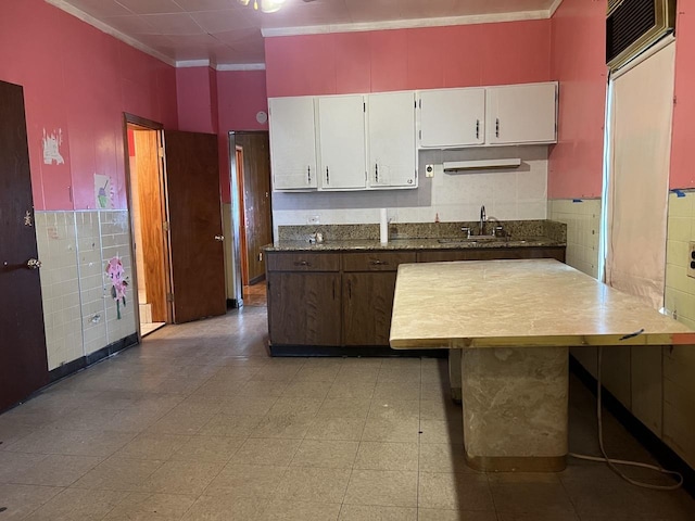 kitchen with white cabinetry, sink, and ornamental molding