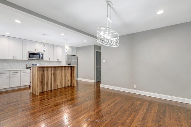 kitchen featuring decorative light fixtures, appliances with stainless steel finishes, dark hardwood / wood-style flooring, a kitchen island, and white cabinets