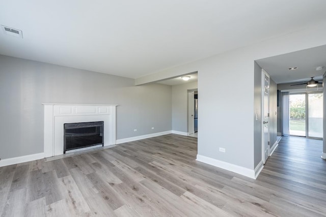 unfurnished living room featuring ceiling fan and light wood-type flooring