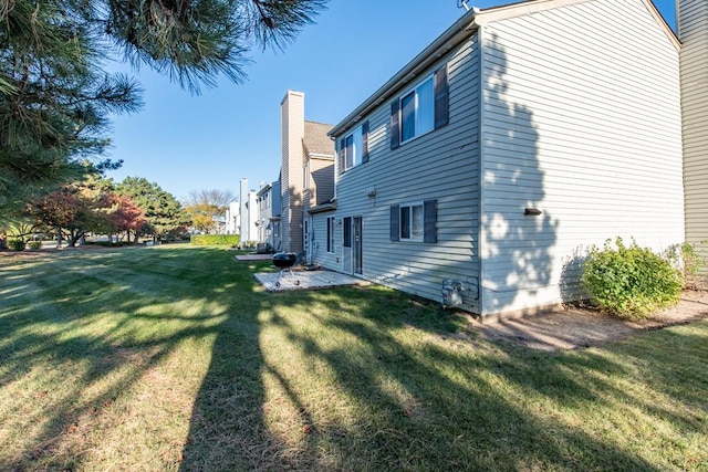 view of property exterior featuring a lawn and a patio