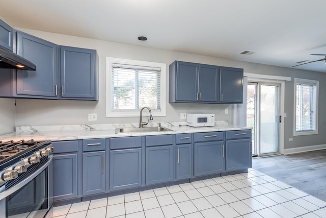 kitchen featuring blue cabinets, sink, a wealth of natural light, and stainless steel gas range