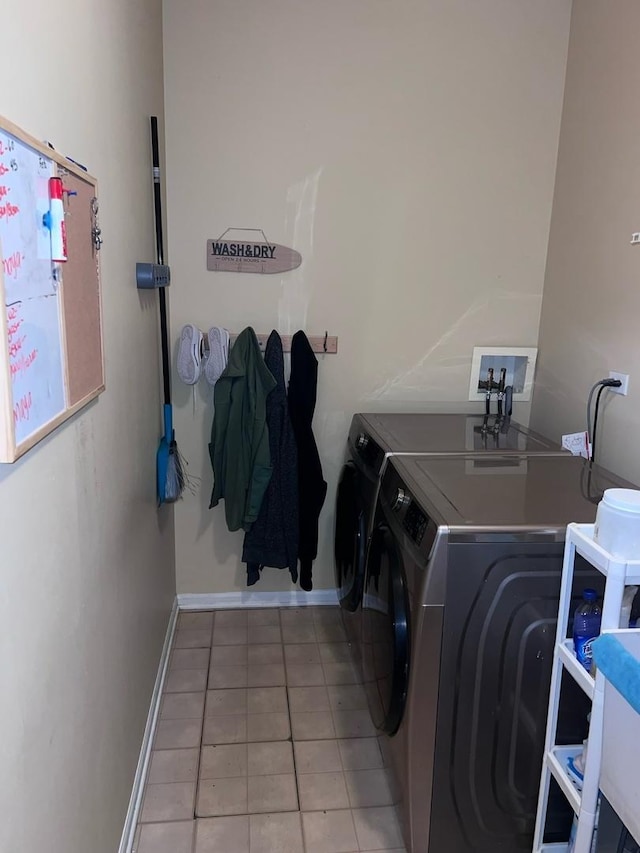 clothes washing area with washer and clothes dryer and light tile patterned floors