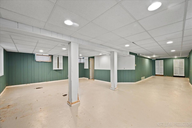 finished basement with a paneled ceiling, baseboards, and recessed lighting