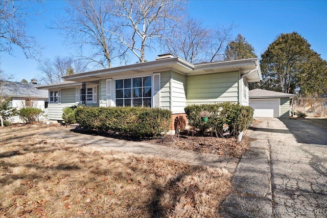 view of front of house featuring an outbuilding, brick siding, and a detached garage