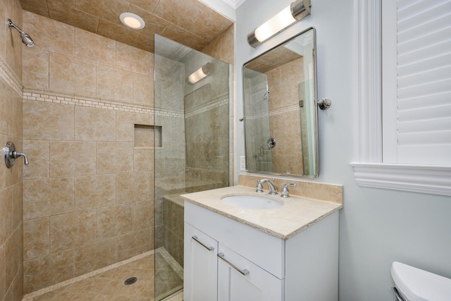 bathroom featuring tiled shower, vanity, and toilet