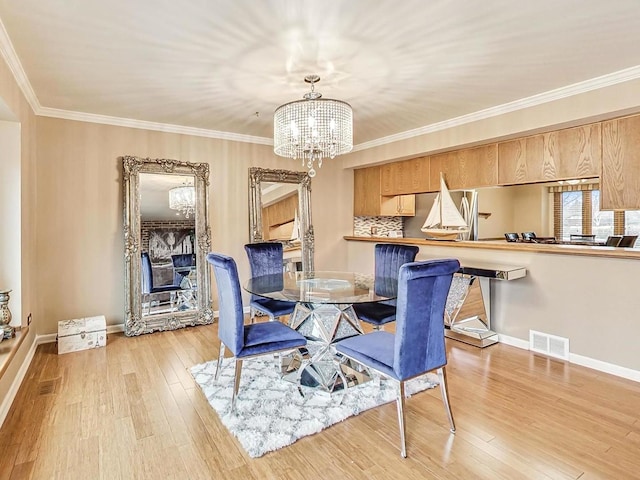 dining room featuring crown molding, a notable chandelier, and light hardwood / wood-style floors