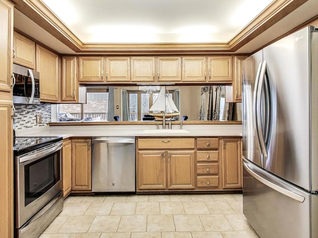 kitchen with sink, decorative backsplash, ornamental molding, and stainless steel appliances