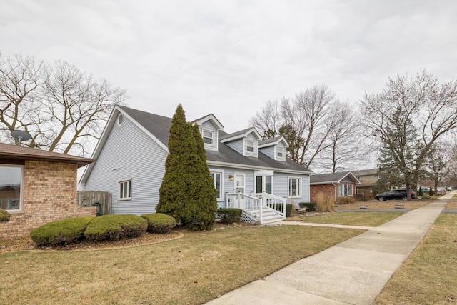 cape cod home with a front lawn