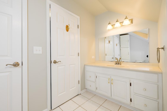 bathroom with vanity, lofted ceiling, and tile patterned floors