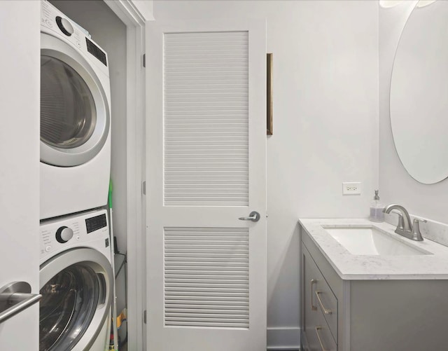 laundry room with stacked washer / drying machine and sink