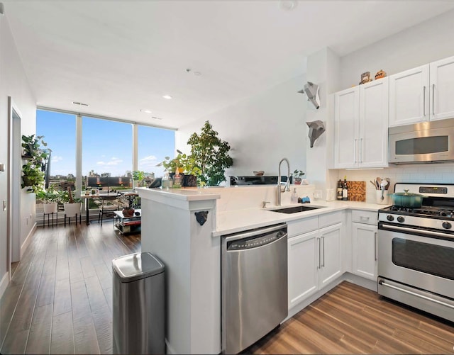 kitchen featuring white cabinetry, sink, stainless steel appliances, and kitchen peninsula