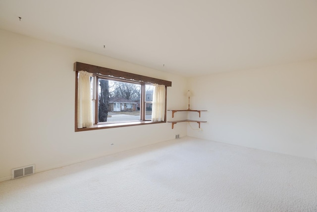 unfurnished bedroom with ceiling fan, light colored carpet, baseboards, visible vents, and ornamental molding