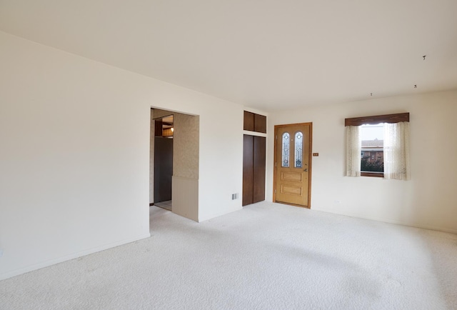 spare room with visible vents, ornamental molding, light carpet, baseboards, and ceiling fan