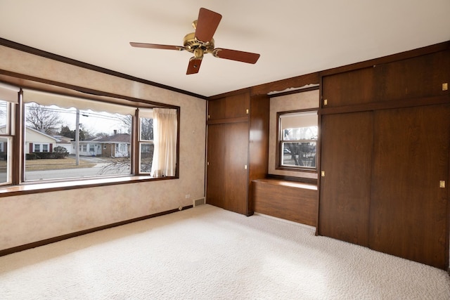 carpeted spare room featuring an inviting chandelier, visible vents, and a wainscoted wall