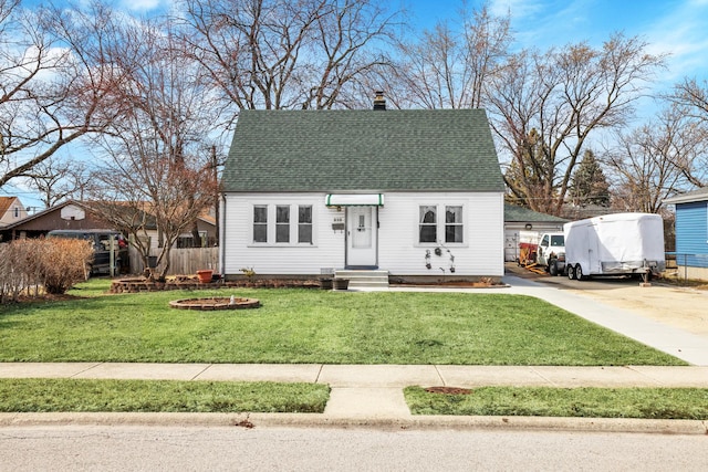 view of front of property with entry steps, a front yard, and roof with shingles