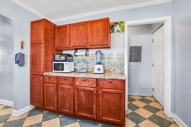 kitchen with white microwave, light floors, ornamental molding, electric panel, and arched walkways