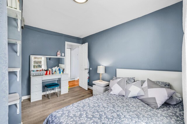 bedroom with wood finished floors and baseboards