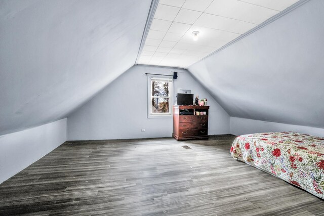 unfurnished bedroom featuring lofted ceiling and wood finished floors