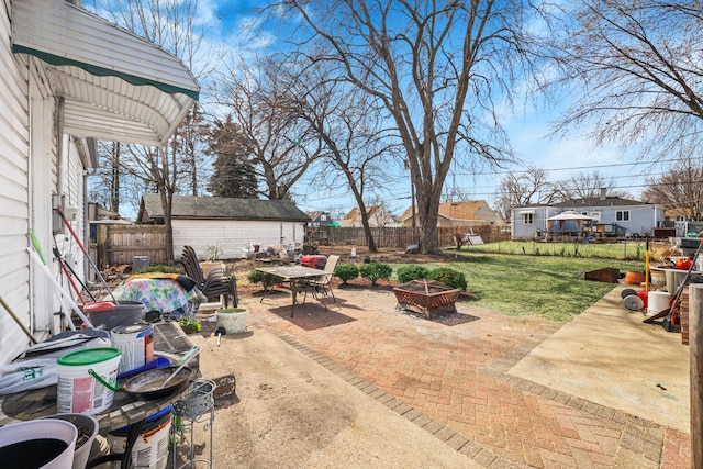 view of patio / terrace with an outdoor fire pit, a fenced backyard, and an outdoor structure