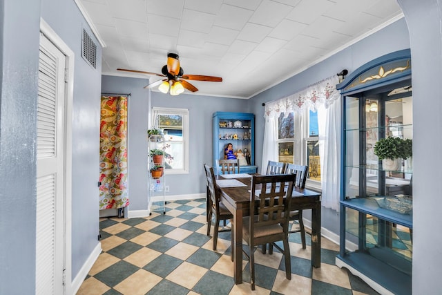 dining area featuring tile patterned floors, a healthy amount of sunlight, baseboards, and ornamental molding