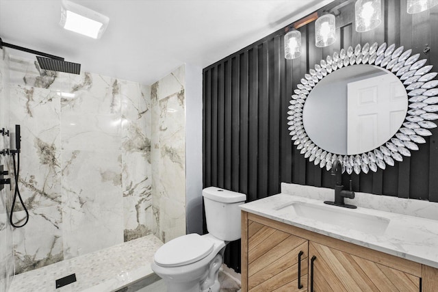 bathroom with vanity, a tile shower, and toilet