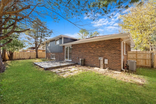 back of house with a lawn and central air condition unit