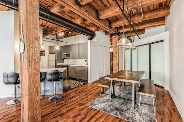 dining space featuring sink, wooden ceiling, dark hardwood / wood-style floors, and beamed ceiling