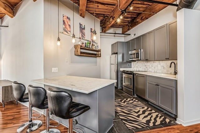 kitchen with sink, gray cabinets, stainless steel appliances, wooden ceiling, and kitchen peninsula