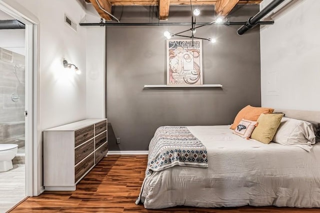 unfurnished bedroom with ensuite bath and dark wood-type flooring