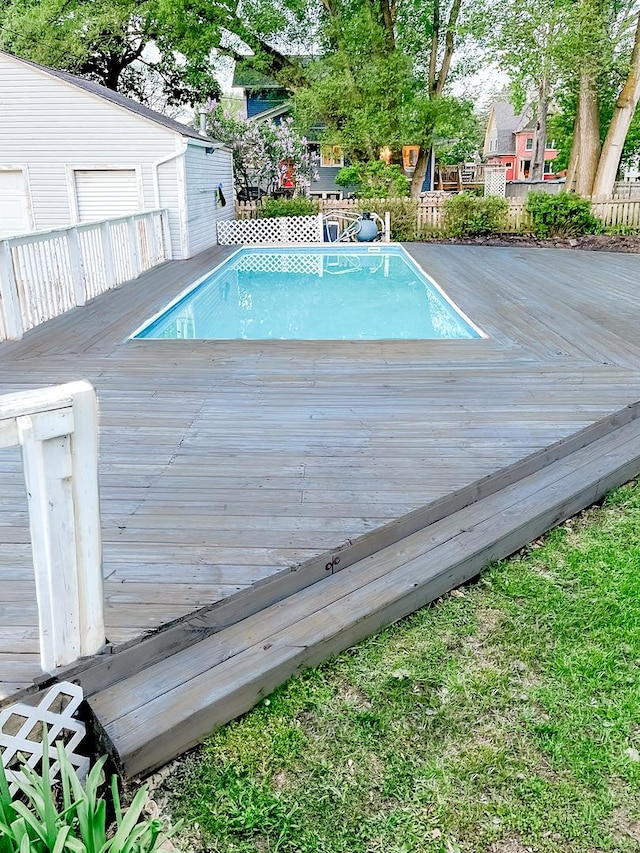 outdoor pool with a deck and fence