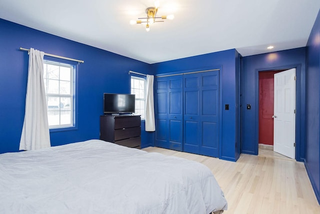 bedroom with light wood-type flooring and a closet