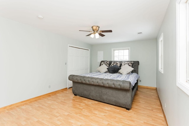 bedroom with a ceiling fan, a closet, baseboards, and wood finished floors