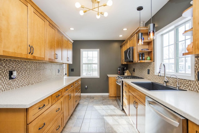 kitchen featuring open shelves, stainless steel appliances, light countertops, a sink, and baseboards