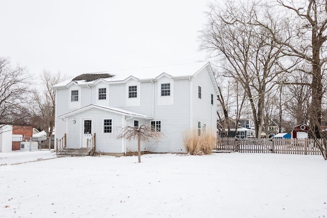 snow covered property featuring fence