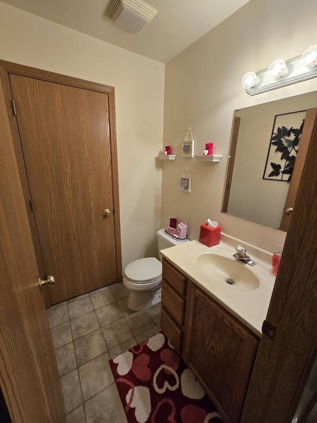 bathroom featuring tile patterned flooring, vanity, and toilet