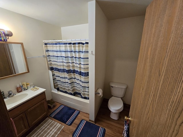 full bathroom with wood-type flooring, shower / tub combo with curtain, vanity, and toilet