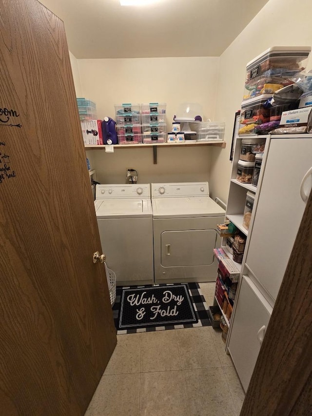 washroom with light tile patterned floors and washer and dryer