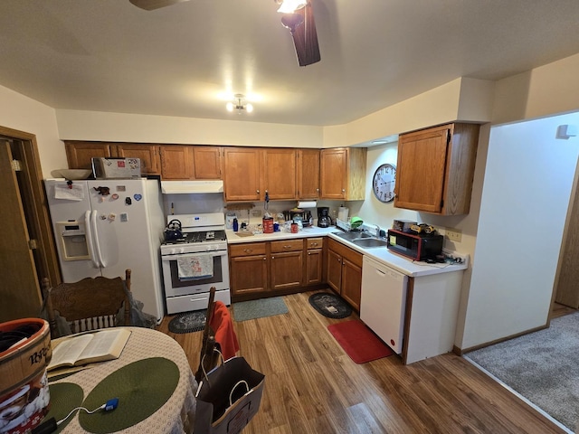 kitchen with ceiling fan, sink, hardwood / wood-style floors, and white appliances