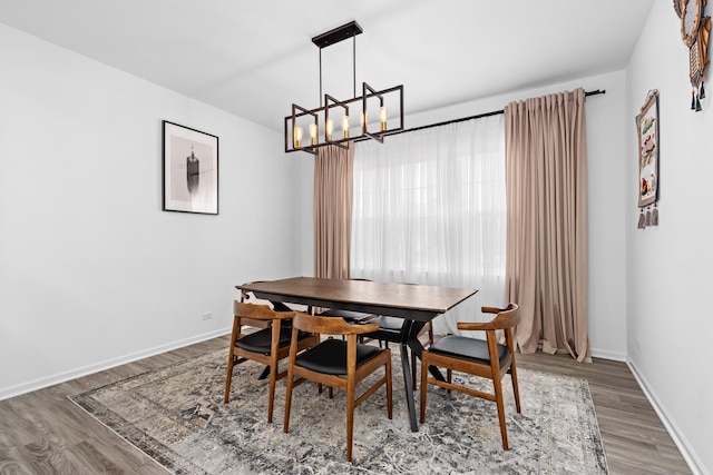 dining area featuring hardwood / wood-style floors and a chandelier