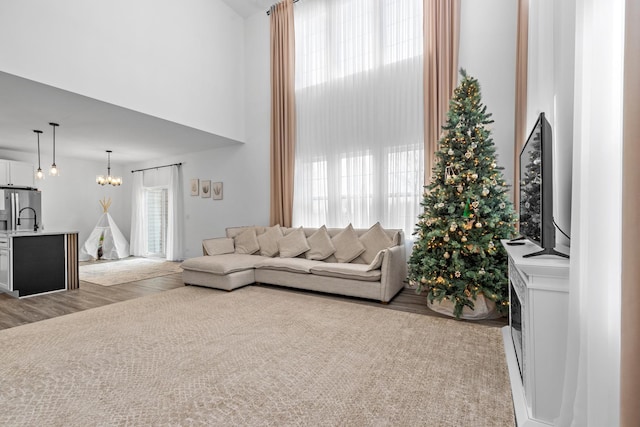 living room with an inviting chandelier, a healthy amount of sunlight, and a high ceiling