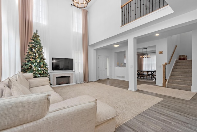 living room with hardwood / wood-style flooring, a high ceiling, and a notable chandelier