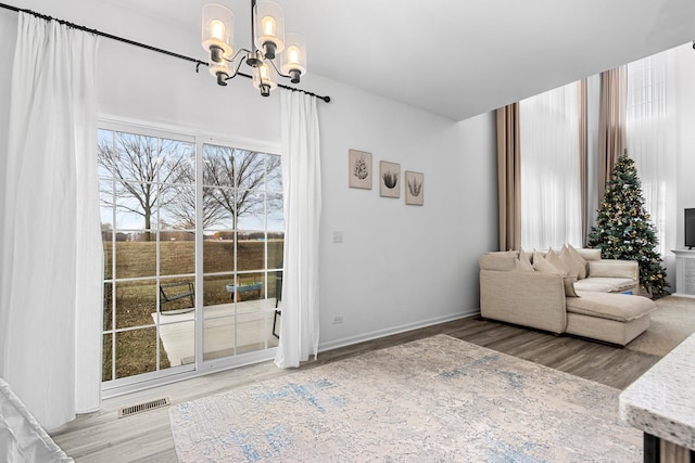 unfurnished living room with wood-type flooring and a notable chandelier