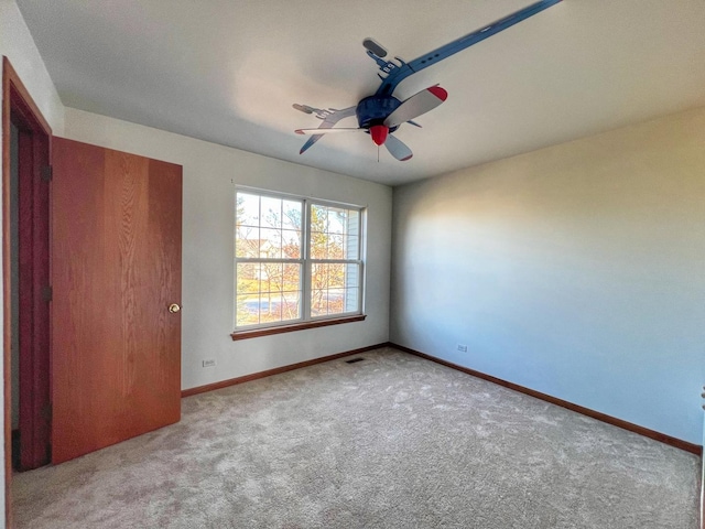 unfurnished bedroom featuring ceiling fan and light carpet