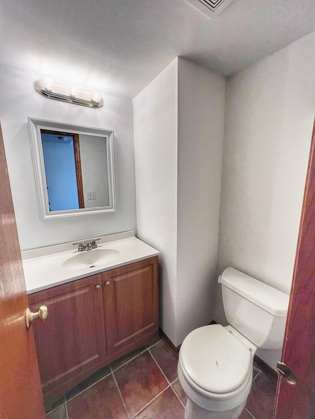 bathroom featuring tile patterned flooring, vanity, and toilet