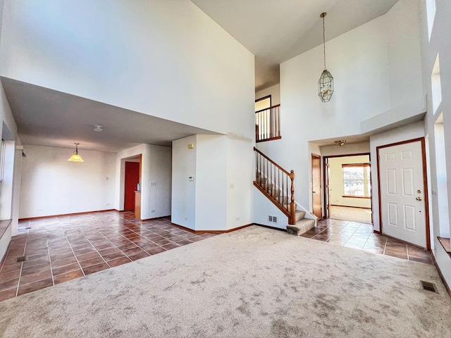 entrance foyer featuring a high ceiling and dark carpet