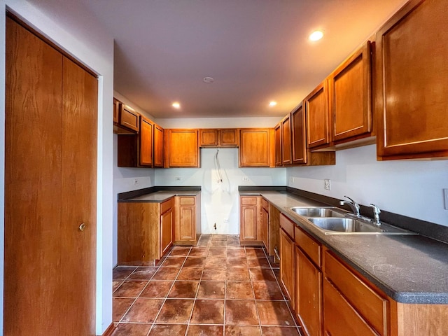 kitchen featuring sink and dark tile patterned flooring