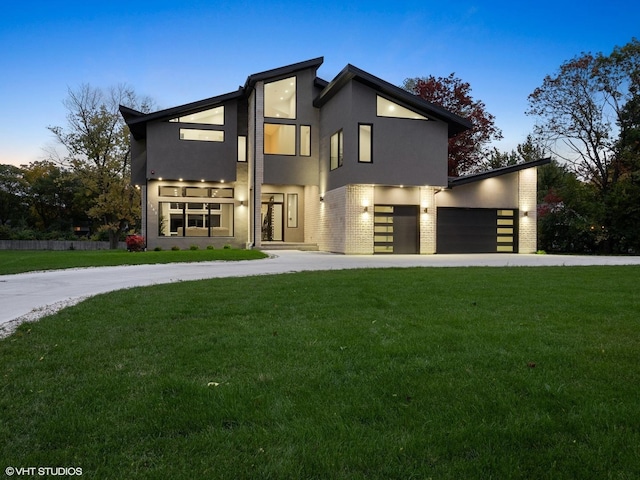 modern home featuring a garage and a yard